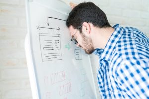 Стресовий бізнесмен біля дошки планує міграцію хостингу без втрати позицій