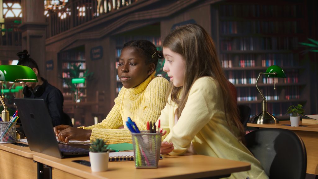 Учні початкової школи в бібліотеці обговорюють шкільний сайт під час онлайн-семінару