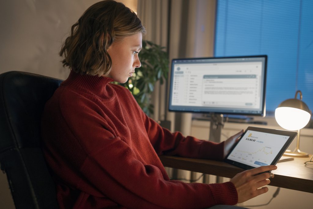 Людина працює вночі за комп'ютером обираючи доменні зони для сайту