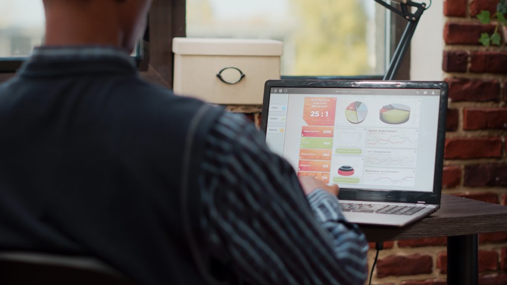 Менеджер аналізує графіки продажів інтернет-магазину на ноутбуці зі швидкістю сайту