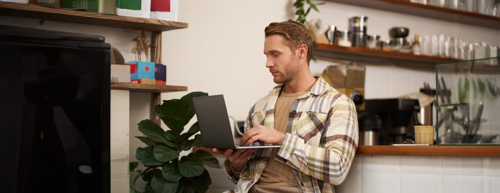 Молодий підприємець із ноутбуком обирає як обрати shared хостинг для сайту