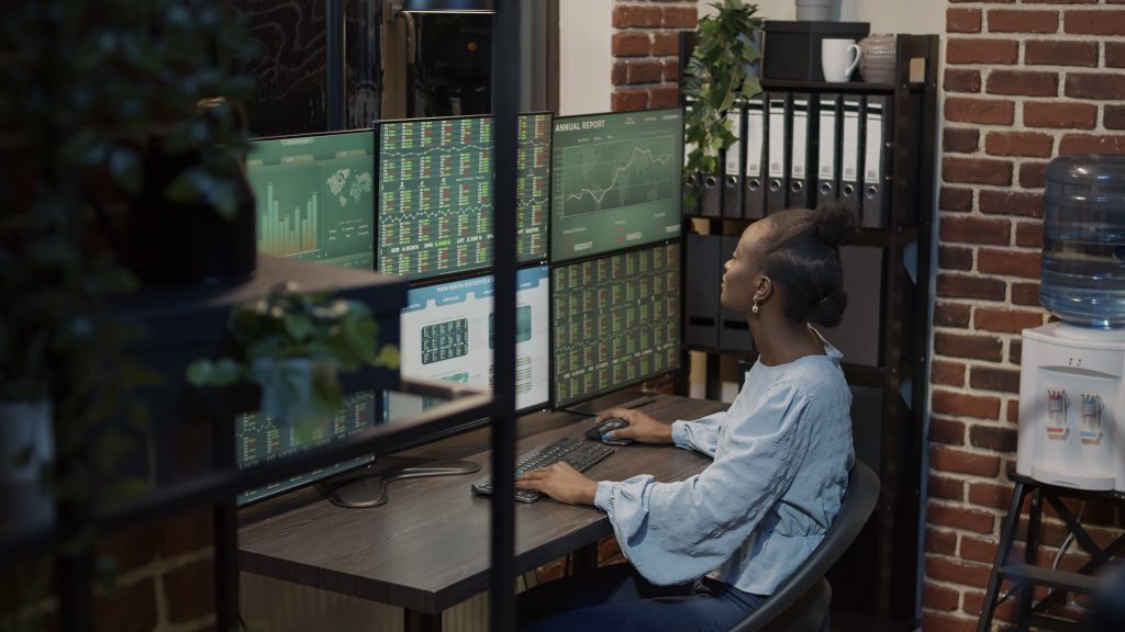 Жінка аналізує графіки та дані для діагностики хостингу на моніторах